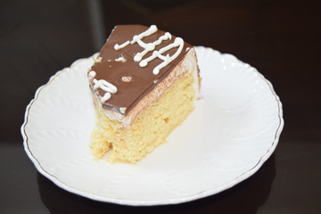 Tasty slice of  three milk cake with white plate and dark background