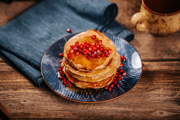 American pancakes with delicious mapple syrup on old wood table on a blue plate
