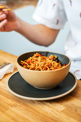 man eating noodle with chicken