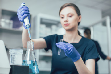 Woman with lab flask at her workplace stock photo