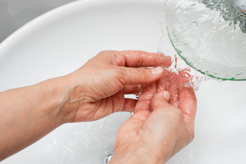washing hands under a tap with water