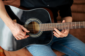 Fototapeta na wymiar Close-up of an acoustic guitar in hands