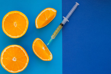 Vitamin C , syringe on fresh juicy orange fruit slides. Conceptual image of mineral,vitamin,medical...