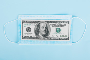 Sale of medical masks. Medical mask with money on blue background. Coronavirus concept. 2019 nCoV.