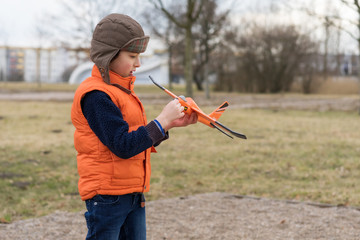 Boy playing in nature with a model of a glider (airplane).