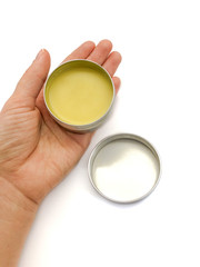 Jar with wax and hand isolated on a white background. Jar of wax. Body cream. Wax for hair removal. Depilation. Aromatic oil. Hygiene product. Body Oil. Hot cream. Skin care.