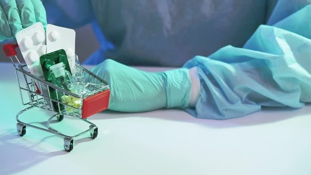 Medication trade. Pharmaceutical business. Hands in gloves moving shopping tray with drugs.