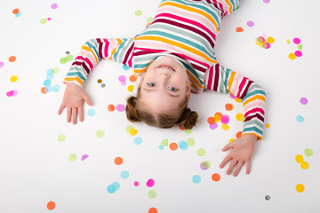 Happy baby girl with confetti on white background
