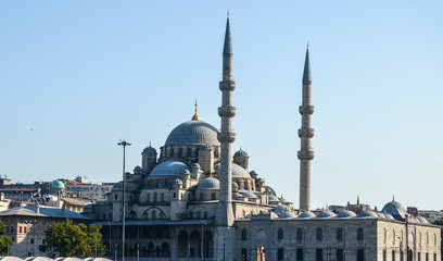  Domes and minaret of new mosque (Yeni Camii) view from Golden Horn, with clear blue sky behind. Istanbul, Turkey.