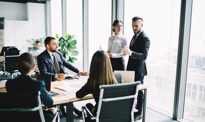 Focused entrepreneur with secretary having meeting with employees