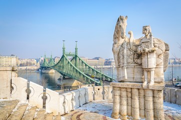 Fototapeta premium The famous statue of King Saint Stephen with his horse and the Liberty bridge on a sunny winter day in Budapest Hungary