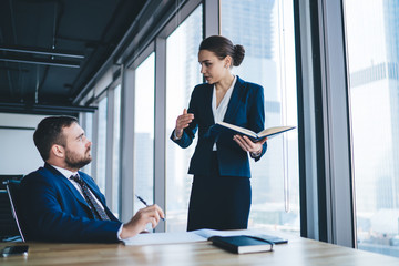 Formal female worker with manager in office