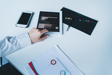 Female studying business plan at workplace and using tablet