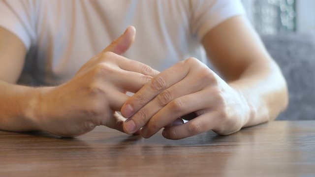 closeup. the man wears a wedding ring, sitting in a cafe.