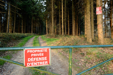 Panneau Propriété privée, Défense d'entrer, Chasse Gardée sur une barrière à l'entrée d'un bois privé