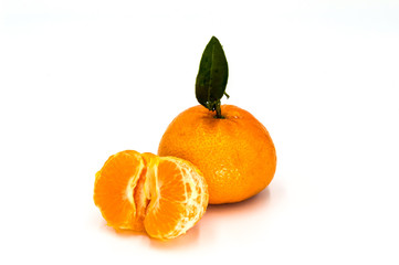 Ripe tangerine with leaves close-up on white