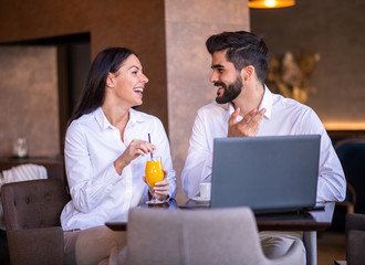 Businessman and businesswoman talking, joking, laughing and smiling.