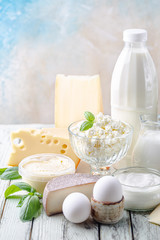 Fototapeta na wymiar Fresh dairy products, milk, cottage cheese, eggs, yogurt, sour cream and butter on wooden table