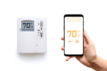 Human hand holding smart phone with smart home heating control system with thermostat regulator of temperature screen isolated on white background. New technology the running of  home