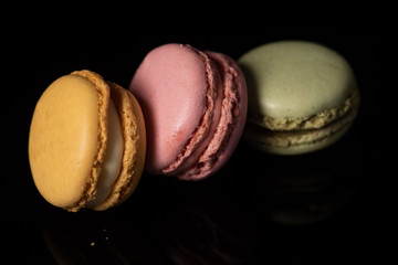 macaroons isolated in reflective black background