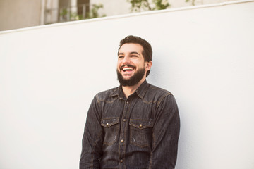 Bearded man laughs in outdoors patio