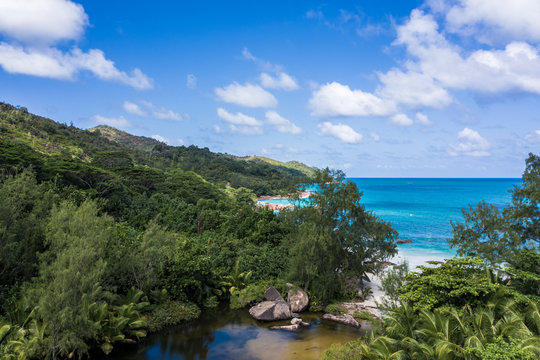 Aerial view of Anse Lazio beach with turquoise ocean, tropical jungle, river and granite rocks, Praslin Island, Seychelles