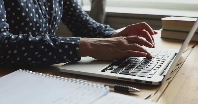Close up young indian woman working on computer, using touchpad, typing corporate message, communicating with clients. Millennial hindu girl student doing homework university assignment on laptop.