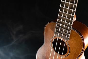 Hawaii ukulele guitar isolated against black background with smoke