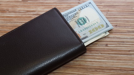 American dollars stacked on a dark background, in a wallet, in a cash drawer