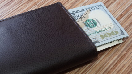 American dollars stacked on a dark background, in a wallet, in a cash drawer