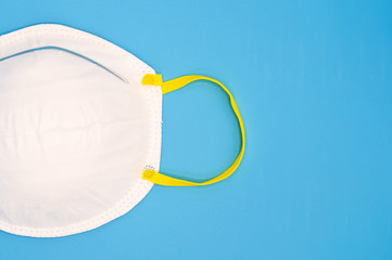 Protective disposable medical mask against coronavirus, flu or influenza on a blue background .