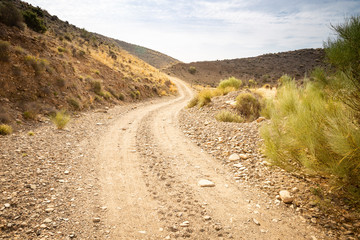 Fototapeta na wymiar a gravel mountain road next to Rambla de Gergal (Santa Fe de Mondujar), Almeria, Andalusia, Spain 