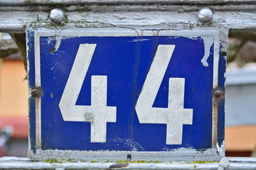 A house number plaque, showing the number fourty four (44)
