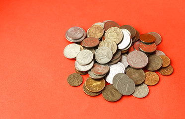 A pile of metal coins on a red background. A lot of Russian rubles. Selective focus. Home savings. Copy space