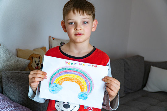 A cute boy with a painted rainbow with EVERYTHING WILL BE GOOD in French, asks for the prevention of the coronavirus covid-19: Campaign on social networks STAY HOME for the prevention of coronavirus
