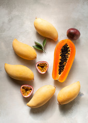 Exotic fruits : papaya, mango, passion fruits on light wooden background 