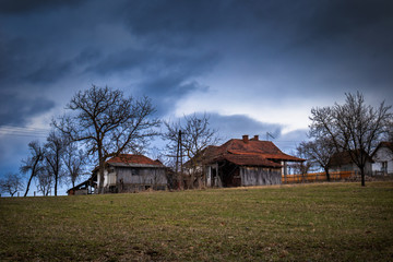 Obraz premium Old houses in the village, cloudy winter sunset