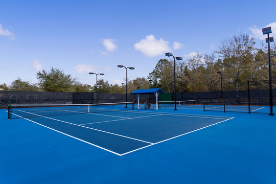 Blue tennis courts with lights