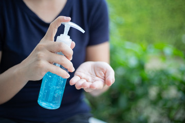 A woman using a hand sanitizer, alcohol gel at home