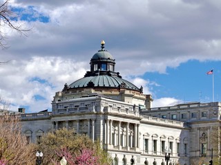 Exterior of Library of Congress building in Washington, D.C. on a blue sky puffy white cloud sunny spring afternoon.