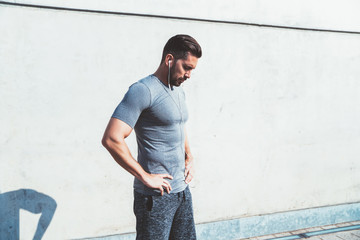 Calm sportsman relaxing after workout exercise in street