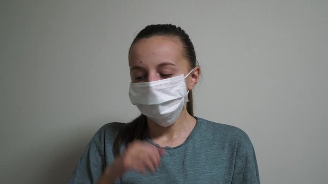 Girl puts on a medical mask so as not to get infected. COVID-19