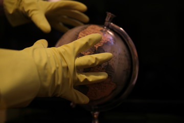 globe in hands wearing protective gloves