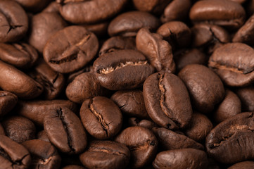 Background of coffee beans macro. Warm brown tones, the lateral scattered light.