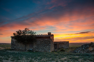 Horizonte de los campos de Aragón al atardecer con casa en ruinas (España).	