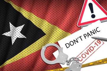 Timor Leste flag and police handcuffs with inscription Don't panic on white paper. Coronavirus or...
