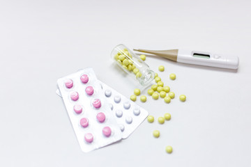 Colorful pills, capsules, tablets and thermometer.