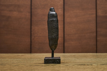 the mineral pyrite is a cylindrical figurine on a wooden background