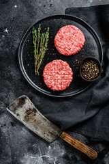 Raw burgers cutlets, organic ground beef meat. Black background. Top view