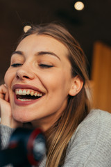 Portrait of a pretty blonde girl sitting in a comfortable coffee shop during a work break, Close up photo of a beautiful female with blue eyes.